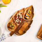Wooden leaf-shaped platter with snacks on a white surface
