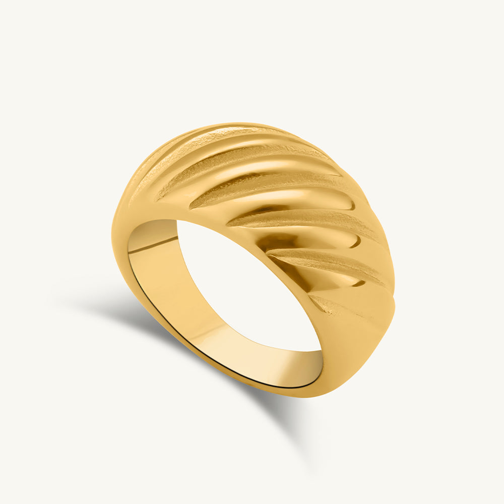 Gold ring with a textured design on a white background